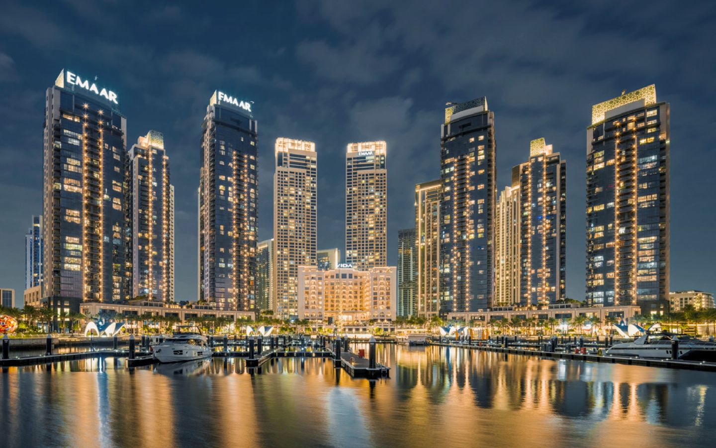 Waterfront commercial and residential towers with city lights along the shoreline
